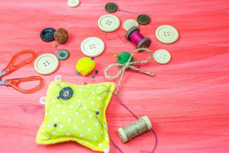 Clothing accessories, thread scissors and buttons on red background