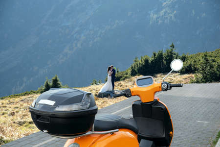 parked orange scooter in the mountainsの写真素材