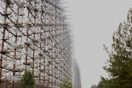 Secret Soviet Radar DUGA-1, called a woodpecker hidden in the forest in the nearby of Prypiat city. Tall metal construction spreading on a wast territory. Barren and dried ground under the radar.のeditorial素材