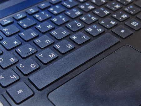 English-Russian laptop keyboard layout in black close-up.