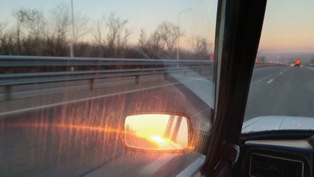 Dawn in the rearview mirror of a car.の写真素材