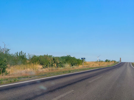 Long road stretching out into the distance under a dramatic blue skyの写真素材