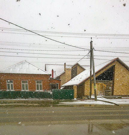 Melting, the first snowfall covering the roofs of houses.の写真素材