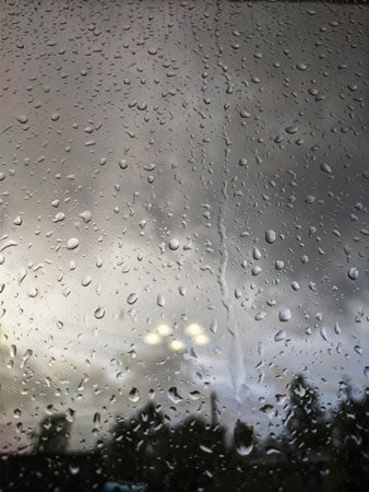 glass covered with raindrops, blurred appearance.の写真素材