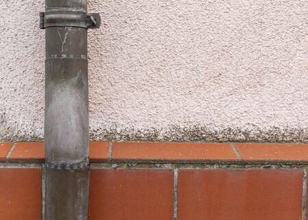 Gutter on the building facade. Sewage system. Steel pipe. Rainwater drainage from the roof. Building elements.の写真素材