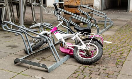 Bicycle parking. Children's bike in the parking lot. Parking space under the shopping center. Urban infrastructure. Toddler's toy Ecological transport. Metal constructions.の写真素材