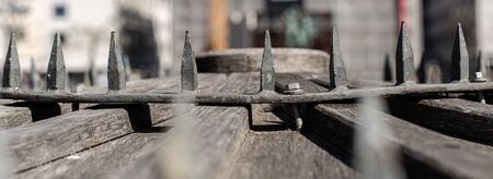 Sharp protective rods. Entrance security. Closed manhole. Historic city well. Historic buildings of the city. Steel wires.の写真素材