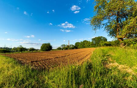 Plowed field. Rural area. Arable land. A small farm in Germany. Blue sky.の写真素材