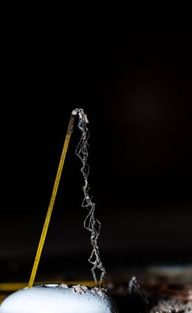 Burnt Incense. Ash and stick. Meditation at home. Ash after incense. Photo on a black background.の写真素材