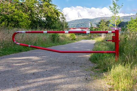 Closed passage. Red barrier. A closed road near the forest. Closed dirt road.の写真素材