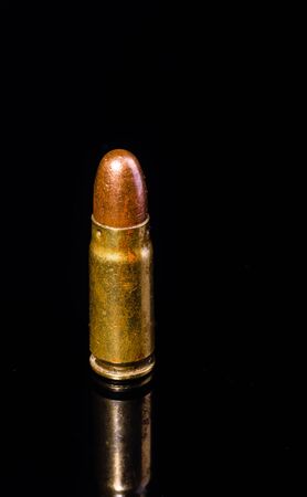 Pistol bullet. Metal case. Cartridge on a black background. Isolated from background.の写真素材