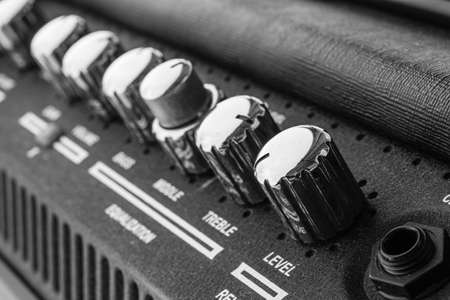 Guitar amplifier macro photography. Control knobs. Electric playing equipment. Black and white picture.の写真素材