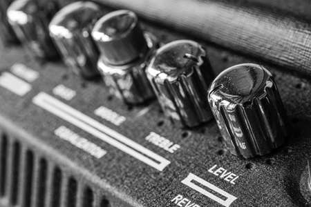 Guitar amplifier macro photography. Control knobs. Electric playing equipment. Black and white picture.の写真素材