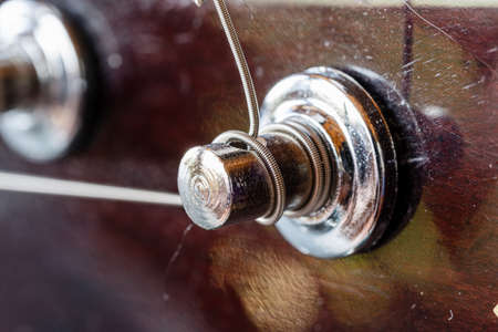 Old guitar keys. Musical equipment macro photo. Metal strings Acoustic guitar.の写真素材