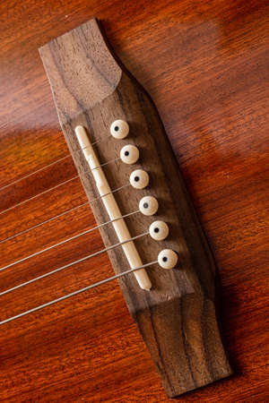 Acoustic Guitar Bridge Wooden instrument. Metal strings Guitar Details. Macro shots of guitar components.の写真素材