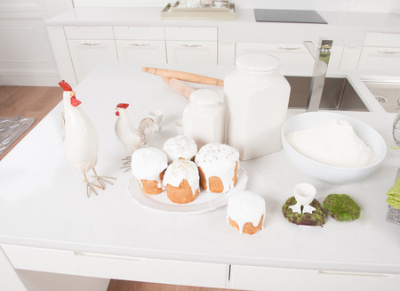 Cakes, flour and cock service are in the kitchen with white furniture in Easter eveの写真素材