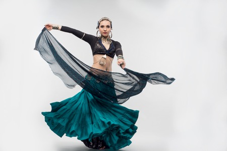 full length portrait of beautiful oriental women,dancing, in a fit of passion, with her amazing scarf  Isolated on white backgroundの写真素材