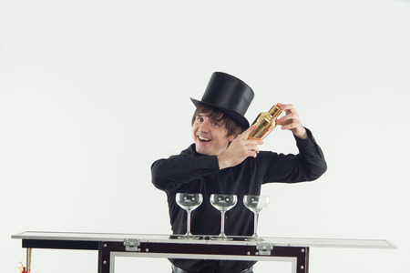 Half-length portrait of handsome dark-haired barman, preparing delicious cocktail with the help of shakerの写真素材