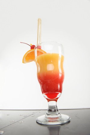 Very delicious cocktail with slice of orange and cherry on it preparing for youの写真素材