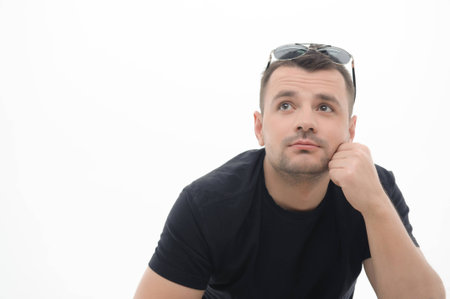 Half-length portrait of handsome man wearing nice black T-shirt and thinking about his wonderful weekend  Isolated on white backgroundの写真素材