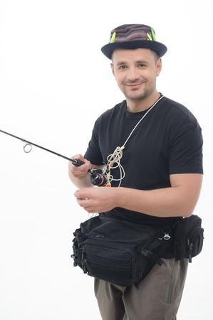 Half-length portrait of fisherman wearing nice cap and holding all his fishing equipment satisfied with his favorite hobby  Isolated on white backgroundの写真素材