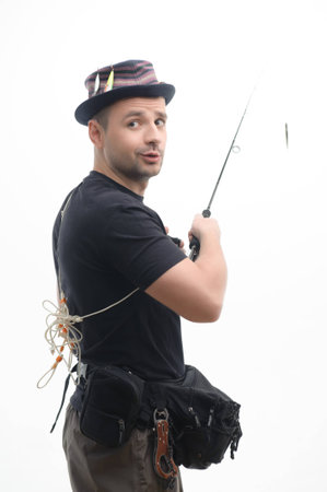 Half-length portrait of handsome fisherman wearing interesting cap with baits standing sideways and looking at us  Isolated on white backgroundの写真素材