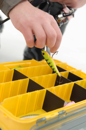Yellow box for fishing baits  One of them in the hands of fishermanの写真素材