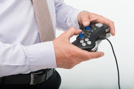 Man wearing great white shirt and nice tie playing a video game using blue joy pad