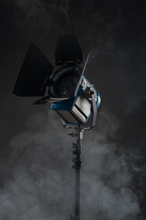 Vintage cinema spot light isolated on black background with smokeの写真素材