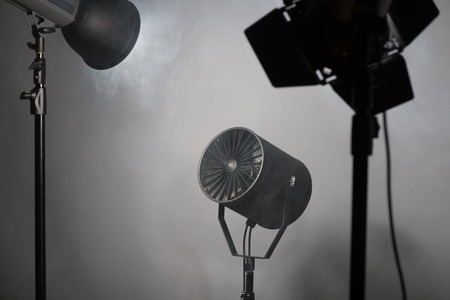 Three projectors standing enveloped in smoke  Isolated on grey backgroundの写真素材