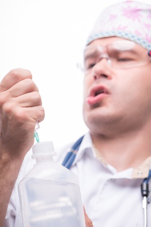 Selective focus on the plastic bottle in the hands of the doctor doing an injection shot on backgroundの写真素材