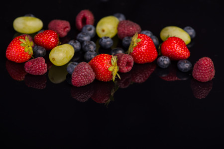 A heap of tempting delicious fruits lying on the black backgroundの写真素材