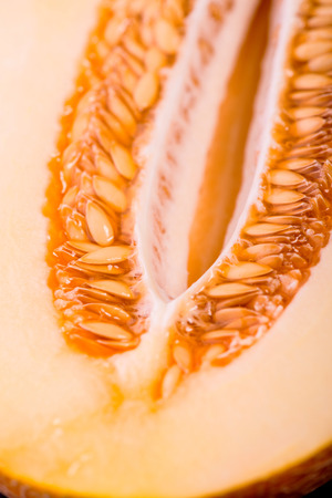 Two halves of the wonderful ripe melon lying on the black vitreous surfaceの写真素材