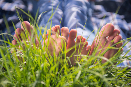 Someones bare feet lying on the grassの写真素材