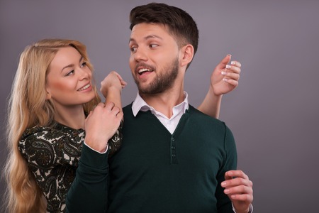 Half-length portrait of beautiful happy couple standing together hugging each other laughing...