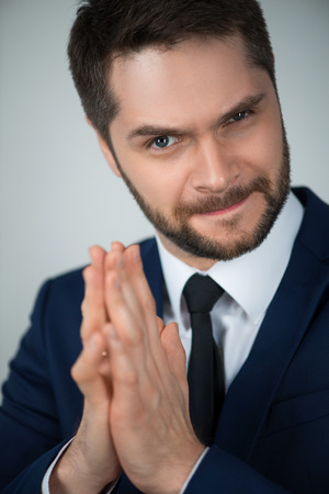 Selective focus on handsome young cunning man wearing white shirt tie and blue suit thinking about the adventureの写真素材