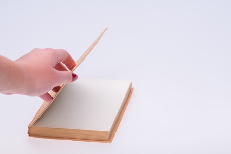 Hands of the woman opening new empty notebook beginning new life isolated on white backgroundの写真素材