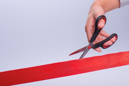 Hands of the man cut the red band. Concept of the new lifeの写真素材