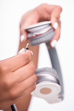 Selective focus on the hand of the girl wanted to turn on her earphones