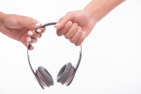 Portrait of the earphones in the hands of man and woman keeping them together. Isolated on white backgroundの写真素材