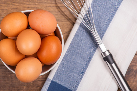 Selective focus on the plate with eggs standing near the checked cloth and mixer on background. Top...