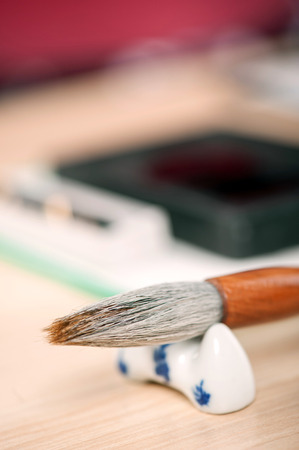 Traditional Japanese or Chinese calligraphy. Closeup of brush for calligraphy practice arranged on wooden tableの写真素材
