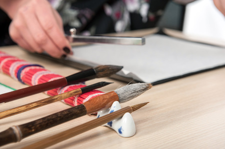 Ready for calligraphy lesson. Side view image of calligraphy brushes of different sizes arranged on wooden tableの写真素材