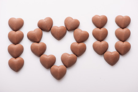 Sweet love. Romantic message composed of chocolate candies isolated on white background.の写真素材
