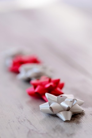 Beautiful festive decor. Image of holiday ribbons of silver and red color placed on wooden table with selective focusの写真素材