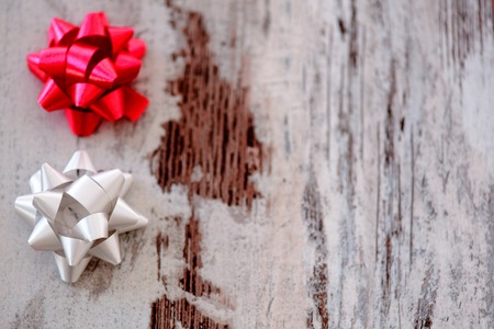 Beautiful festive decor. Top view image of holiday ribbons of silver and red color placed on wooden table with copy spaceの写真素材
