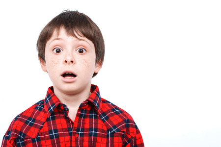 Portrait of a small boy looking very surprised holding his mouth opened wearing checkered shirt isolated on white backgroundの写真素材