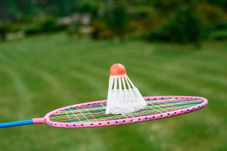 Active vacation. Picture of a badminton racquet holding in the air and a shuttlecock on it, close upの写真素材