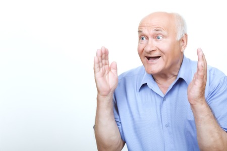 Great surprise. Furious grandfather holding his hands up and feeling surprised isolated on white background.の写真素材