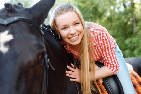 My best friend. Vivacious girl laying on the horse and expressing positive emotions.の写真素材